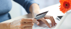 Person entering a credit card number on a laptop